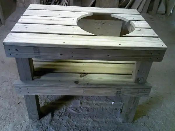 A wooden table with a hole cut for a grill