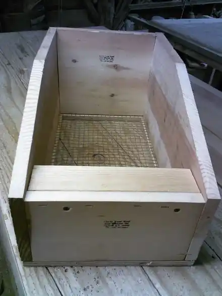 A plywood rabbit nesting box with its insert, empty