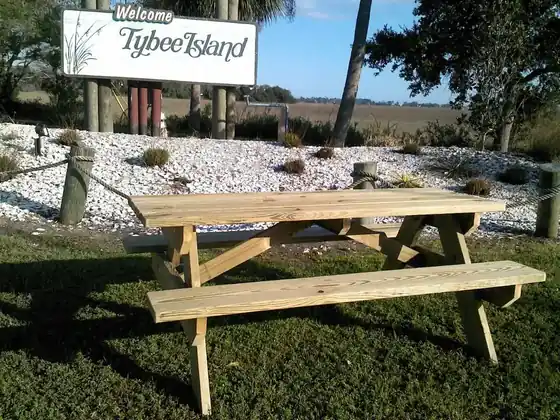 A Clark's Woodwork picnic table standing in front of the Tybee Island sign